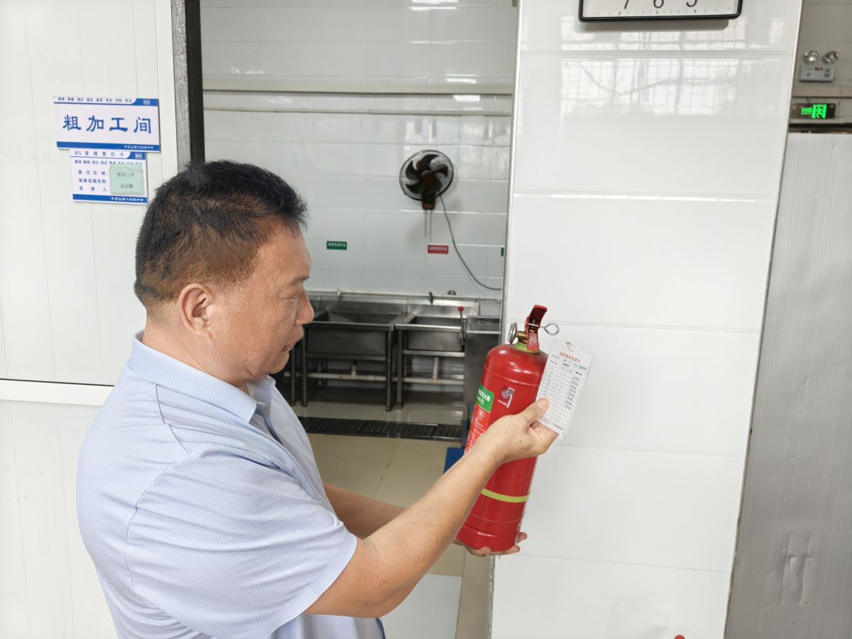 市二高党委委员、副校长杜绍乐检查食堂灭火器